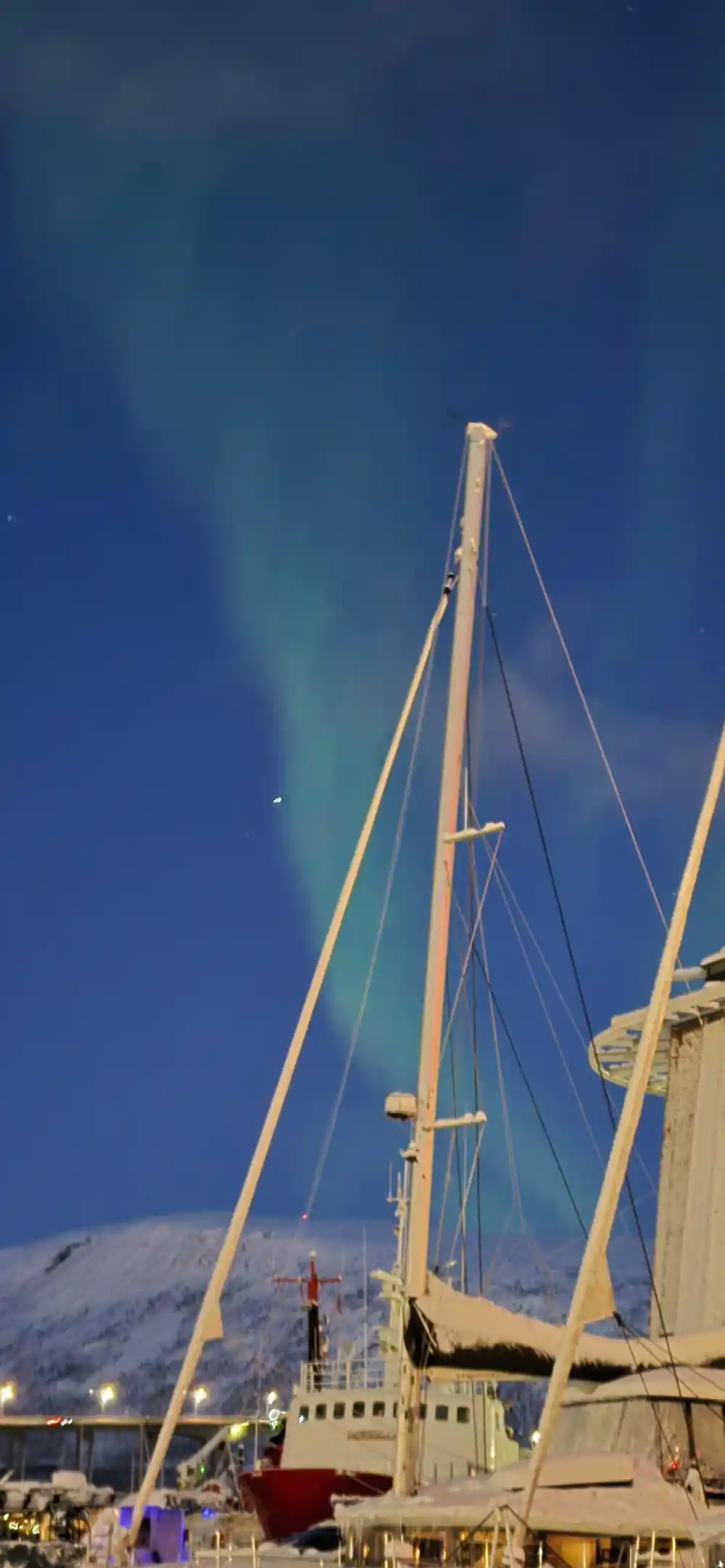 Aurora over the mast and rigging of the boat