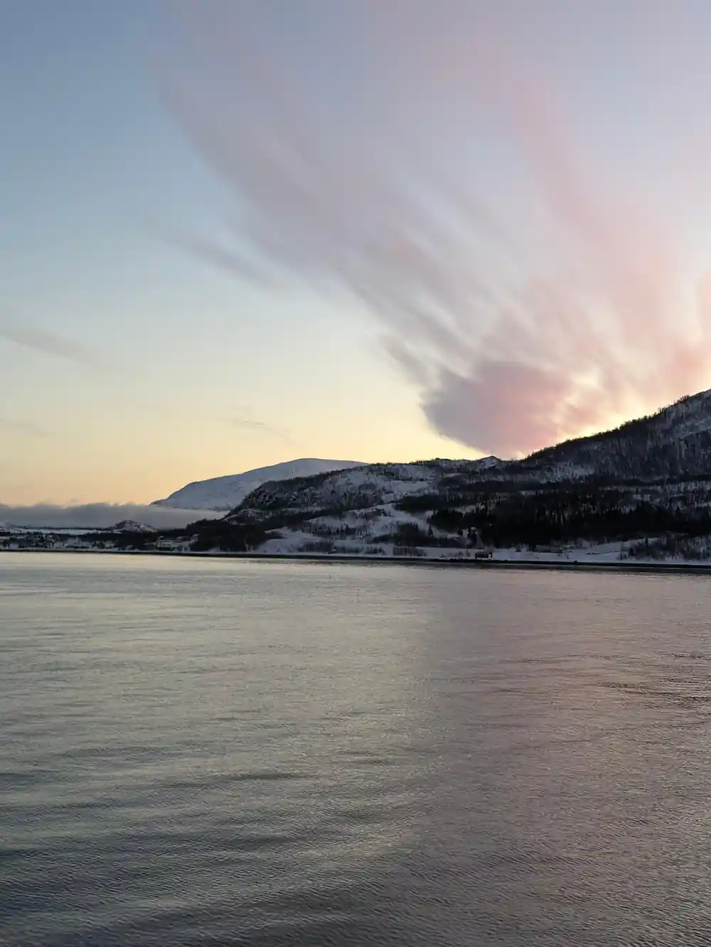 A cloud plume off a headland in flat evening light