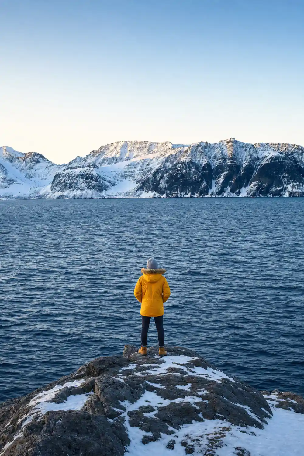A long snow escarpment above dark water