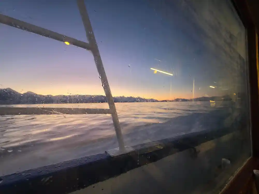 Spray on the wheelhouse glass with the sunrise beyond