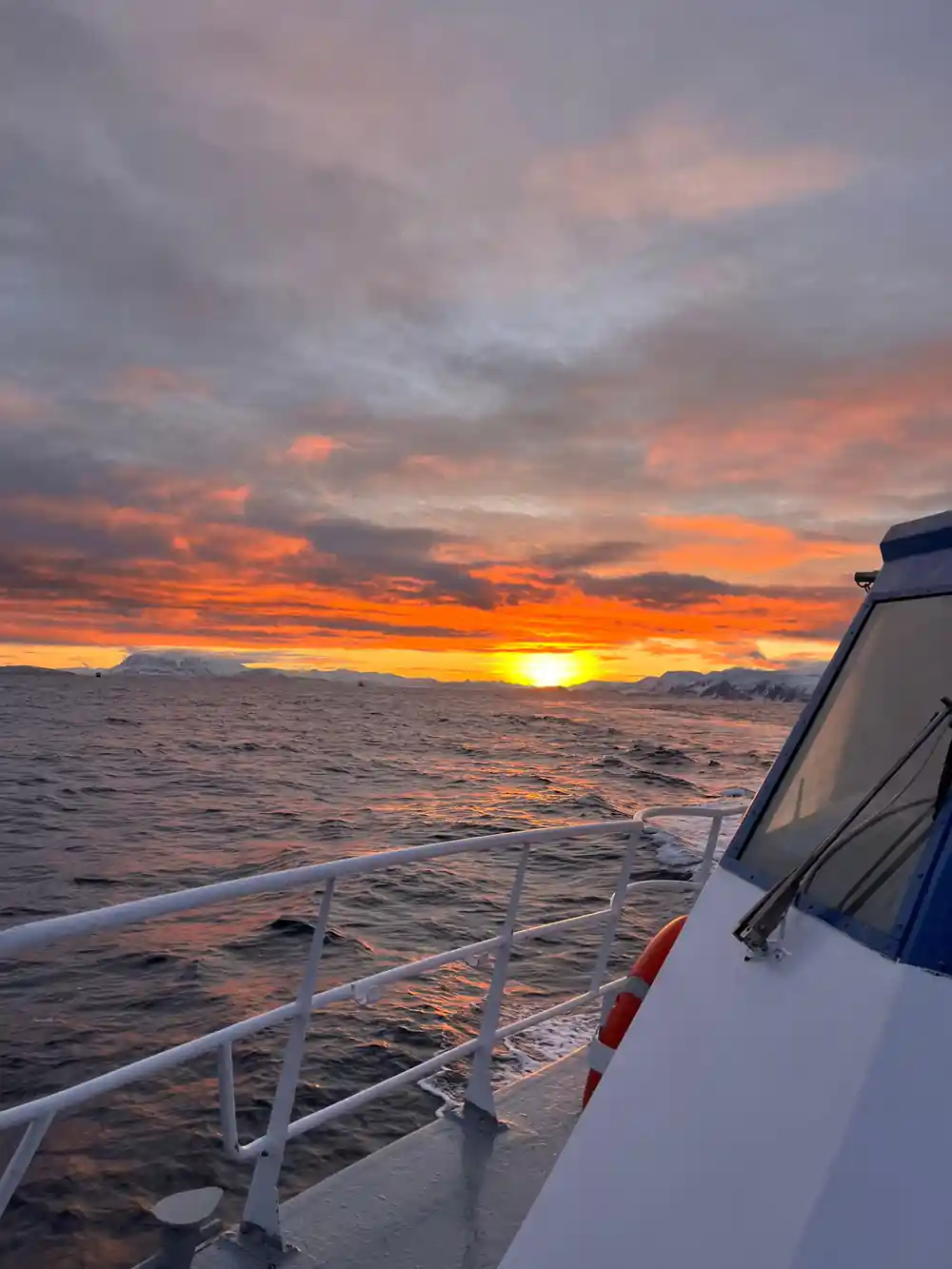 Sunrise over the fjord seen past the wheelhouse