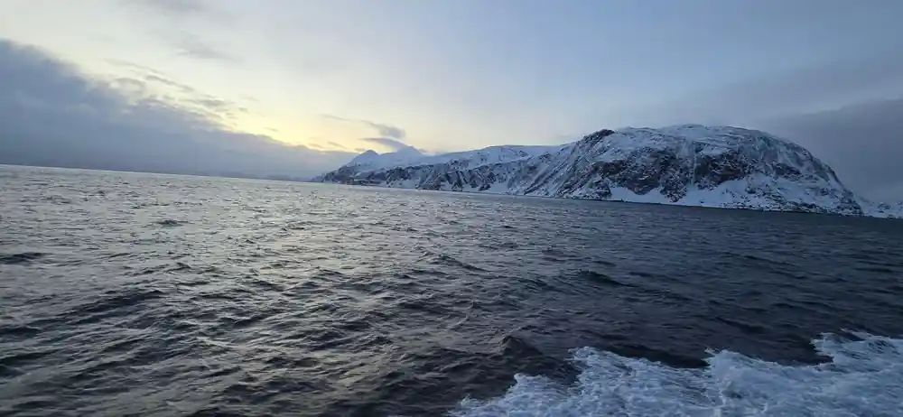 The wake and the snow ridge line from the moving boat